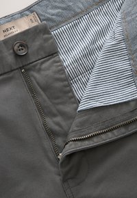 Pantalon gris foncé coupe décontractée avec fermeture éclair ouverte, fermeture par bouton et tissu de ceinture intérieur rayé, taille 32R par NEXT.