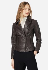 Braune Leder-Motorradjacke mit taillierter Passform, Spitzenrevers, asymmetrischem Reißverschluss vorne und strukturierten Schulterakzenten. Verfügt über Reißverschlusstaschen.