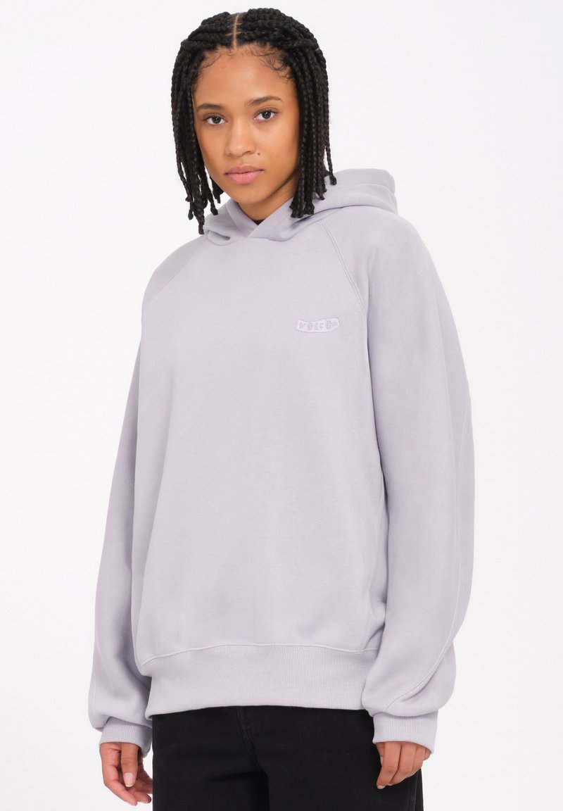 Haut à capuche gris clair avec une coupe décontractée, des poignets et un ourlet côtelés, et un petit logo brodé sur la poitrine. Tissu au toucher doux.