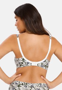 Sostén con un patrón floral verde, tirantes blancos y cierre de gancho y ojo en la espalda. Tejido suave con una textura lisa y bordes fruncidos.