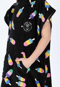 Poncho in tessuto nero con un motivo di ghiaccioli colorati. Presenta una tasca con un logo. Texture morbida e design senza maniche per il massimo comfort.