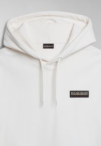 Sudadera blanca con capucha ajustable, puños de canalé y un parche de logo negro y color cosido en el lado izquierdo del pecho. Textura suave.