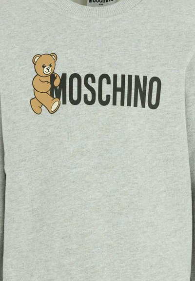 Felpa grigia con un orso in stile cartone animato e il testo "MOSCHINO" in grassetto nero. Realizzata in un tessuto morbido e testurizzato.