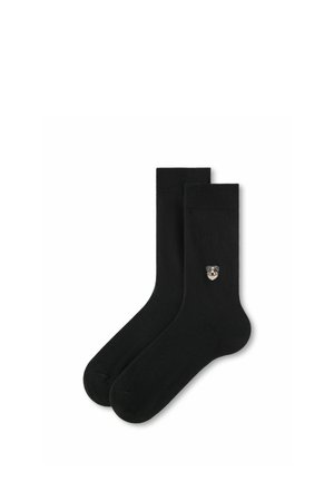 Paire de chaussettes noires montantes avec un petit détail brodé d'un visage de chien sur le côté extérieur d'une chaussette.