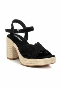 Sandalia de esparto negra de ante con un diseño tejida en la parte superior, correa en el tobillo y un tacón cuadrado envuelto en yute.