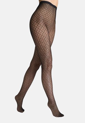 Nogi w czarnych, wzorzystych rajstopach kabaretowych z diamentowym splotem i jednolitym czarnym paskiem, ustawione jedną stopą na drugiej.