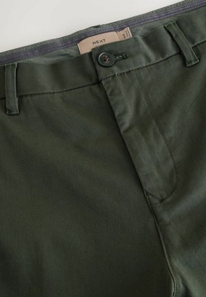 Vihreät puuvillahousut, joissa on sileä pinta, napin suljenta, vyölenkit ja rento muotoilu. Tunnuksessa lukee brändin nimi "NEXT."