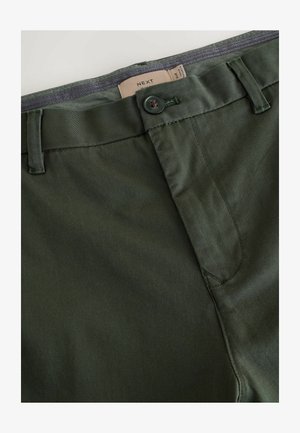 Vihreät puuvillahousut, joissa on sileä pinta, napin suljenta, vyölenkit ja rento muotoilu. Tunnuksessa lukee brändin nimi "NEXT."