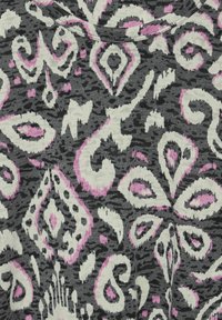 Černá látka s bílým a růžovým paisley vzorem, s jemnou texturou a kulatým výstřihem. Design zahrnuje tvary diamantů a spirál.