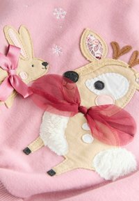 Pink fabric with stitched deer and rabbit, both wearing sheer red bows, with small embroidered white snowflakes above them.