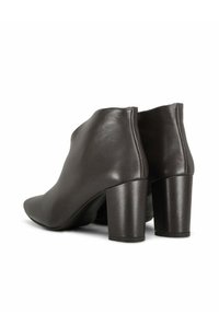 Bruine leren enkellaarsjes met een gladde afwerking, puntige neus en blokhak van gemiddelde hoogte. Eenvoudig ontwerp met strakke lijnen en naadloze achterkant.