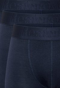 Mörkblå boxerkalsonger med en mjuk yta, prydda med ett brett midjeband präglat med varumärket "Resteröd." Tyget är slätt och elastiskt.