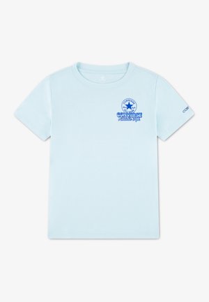 T-shirt en coton bleu clair à manches courtes. Présente un col rond et un motif graphique à l'avant avec un texte bleu et un logo.