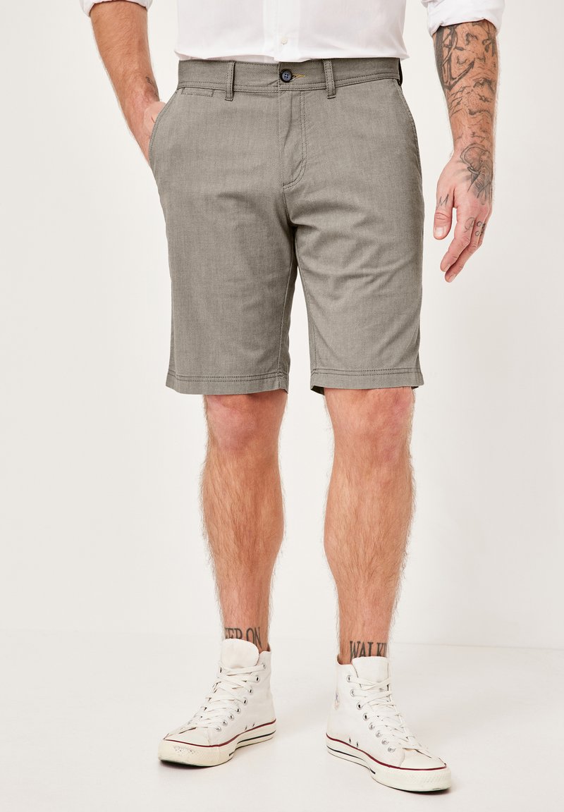 Grau karierte Shorts mit geradem Schnitt, seitlichen Taschen und Knopfverschluss. Der Stoff scheint leicht und atmungsaktiv zu sein.