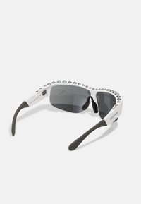 Gafas de sol blancas con lentes grises, con un marco texturizado adornado con cristales transparentes a lo largo del borde superior y patillas flexibles en negro.