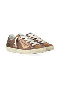 Une paire de sneakers basses en bronze métallique avec des lacets blancs, des semelles en caoutchouc beige et un design en chevrons sur les côtés.
