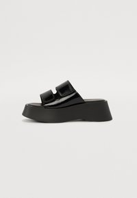 Black patent leather platform sandals with two adjustable straps. Features a thick black sole with a wedge shape and smooth texture.