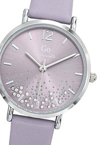 Montre ronde en argent avec un cadran métallique rose, des marqueurs d'heure en argent et des accents en cristal. Elle est dotée d'un bracelet en cuir lavande clair.
