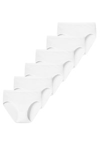 Six culottes blanches en coton pour femmes disposées en une pile en cascade sur un fond blanc.