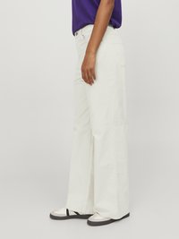 Wide-leg pants made of light-colored fabric feature a high waist and side pockets. The design is complemented by a classic denim texture.