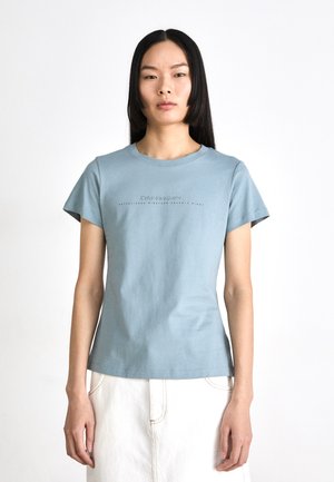 Light blue cotton t-shirt with a round neck and short sleeves, featuring a printed logo in dark gray across the chest. Smooth texture.