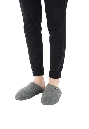 Gray felt slippers with open back, rounded toe, and rubber sole, paired with black tapered pants featuring ribbed cuffs.