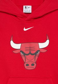 Rdeča kapuca s velikim črnim in rdečim logotipom Chicago Bulls ter glavo bika. Logotip Nike v beli barvi nad grafiko. Material: bombaž.
