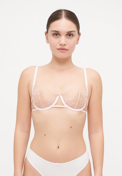 Soutien-gorge rose clair avec des bonnets en mesh transparent ornés de broderies florales, un soutien-gorge à armatures et de fines bretelles ajustables.