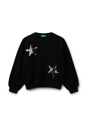 Sweatshirt noir à manches longues avec deux grandes étoiles en sequins argentés, l'une en haut à gauche et l'autre près du bas à droite à l'avant.