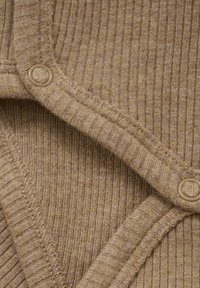 Tissu côtelé marron avec une texture à tricot serré, présentant un col arrondi et deux boutons d'une couleur complémentaire.