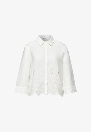 Hvid langærmet skjorte med knapper, spids krave og blomsterbroderi med hulmønster langs den nederste front og med bølget kant.