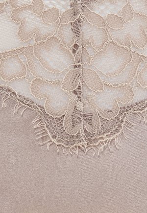 Spitzenrand in sanftem Beige mit floralen Mustern und fransigen Kanten, der auf glattem Satin in passendem Farbton liegt.