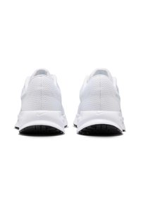 Baskets blanches avec une tige en mesh respirant, un col rembourré et une semelle incurvée ; semelle extérieure en caoutchouc noir avec motif d'adhérence. Logo Nike au talon.