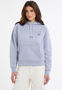 Felpa azzurra chiara con cappuccio, tasca frontale e lacci bianchi. Presenta un logo circolare con una stella blu e testo. Materiale in misto cotone.