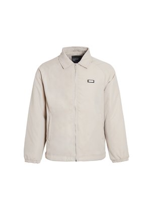 Lys beige zip-jakke med krave, lange ærmer og logo detalje på brystet. Glat tekstur, afslappet pasform og elastiske manchetter.