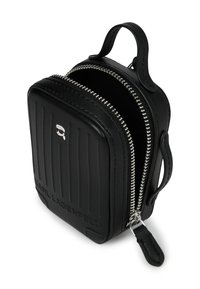 Czarny skórzany plecak w stylu torby z ryflowanym przodem, srebrnym zamkiem błyskawicznym i detalem z logo. Posiada górny uchwyt i zaokrąglone krawędzie.