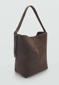 Sac à épaule en suede marron avec une large sangle réglable, d'une texture lisse et d'un design minimaliste présentant une couture à l'avant.
