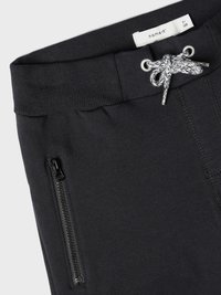 Svarte joggebukser med bred elastisk midje med snøring, sidelommer med glidelås og glatt tekstur.
