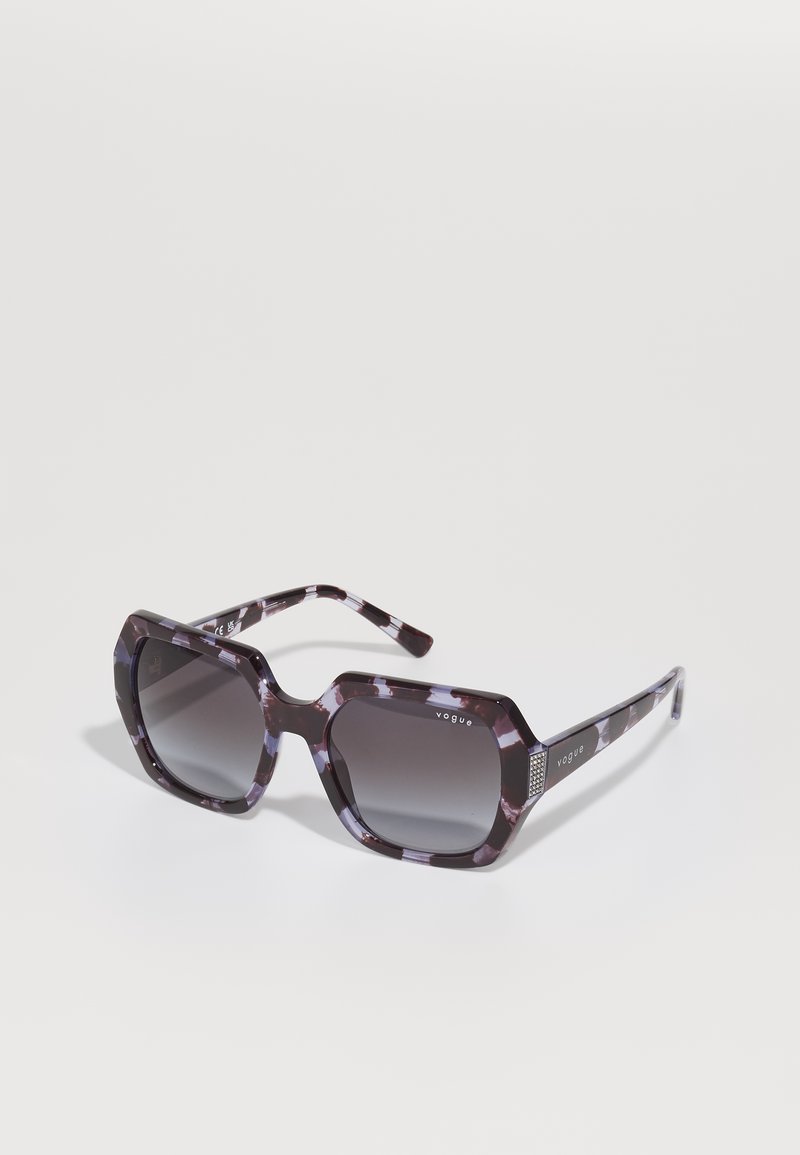 Óculos de sol oversized com um padrão de tartaruga em preto e roxo mate. Lentes com gradiente escuro e um detalhe em prata na armação com a marca "vogue".