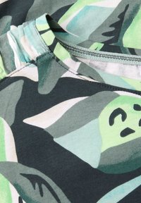 Baumwoll-T-Shirt mit rundem Ausschnitt, in einem dunkelgrünen Farbton mit übergroßen abstrakten Blattformen in verschiedenen Grüntönen und Türkis.