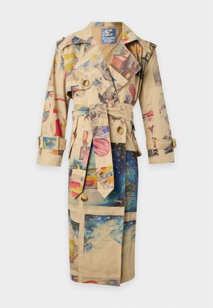 Homme portant un trench-coat beige avec des imprimés colorés de bâtiments et de tramways, chemise rouge, pantalon crème à motifs et chaussures marron.