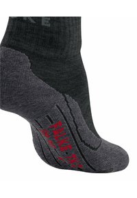 Calcetín gris oscuro con patrones texturizados en contraste y marca roja en la suela. Presenta talón y puntera reforzados para mayor durabilidad.