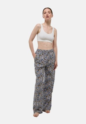 Pantalon léger bleu et blanc à motif floral avec une taille élastique et des poches latérales, associé à un débardeur cropped blanc.