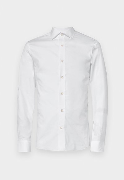 Valkoinen pitkähihaista puuvillapaitaa, jossa on klassinen kaulus, etupainike ja nappi- ja hihansuut. Sujuva rakenne ja muotoiltu istuvuus.