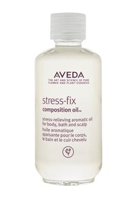 Aveda Stress-Fix Composition Oil in een heldere plastic fles met een witte, geribbelde dop. Het label heeft paarse tekst en een bloemenlogo.