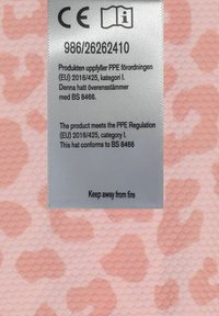 Rosa stof med et struktureret mønster, der ligner dyrespots. Inkluderer et sølvmærke med sikkerhedsinformation og instruktioner, der siger "Hold væk fra ild."