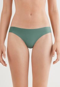 Gröna bikiniunderdelar gjorda av ett slätt tyg. Låg midja med en enkel form och sömlösa kanter som erbjuder minimal täckning.