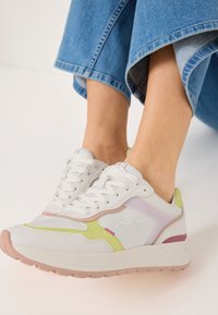 Weiße Sportsneaker mit Pastellgrün-, Pink- und Lavendelakzenten. Glatte Textur, Schnürdesign und leichte Sohle mit strukturiertem Grip.