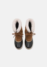 Botas impermeables marrones y negras con un forro blanco esponjoso. Incluyen un puntera redondeada, cordones y una suela de goma texturizada.