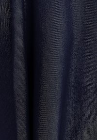 Granatowa tkanina o gładkiej fakturze, z ukośnym prążkowanym wzorem i subtelnym połyskiem. Materiał wydaje się lekki i elegancko układa się.